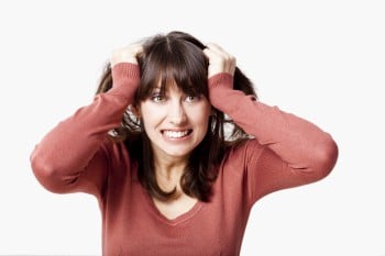 Stressed young woman pulling her hair out