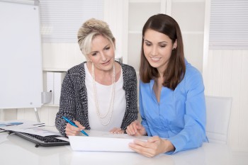 Two attractive business woman in meeting analyzing budget.