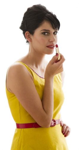beautiful lady in yellow dress applying lipstick