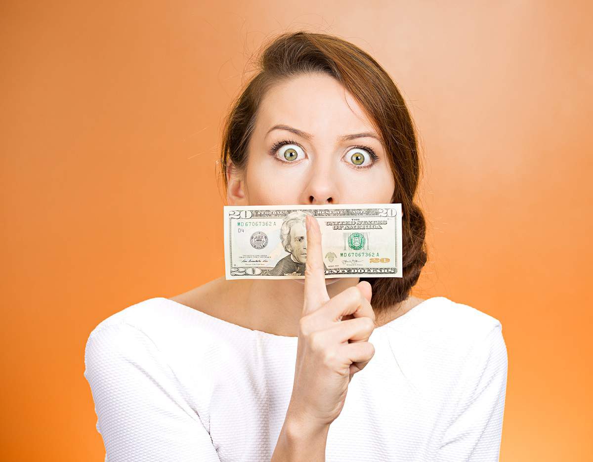 woman with money and finger over lips