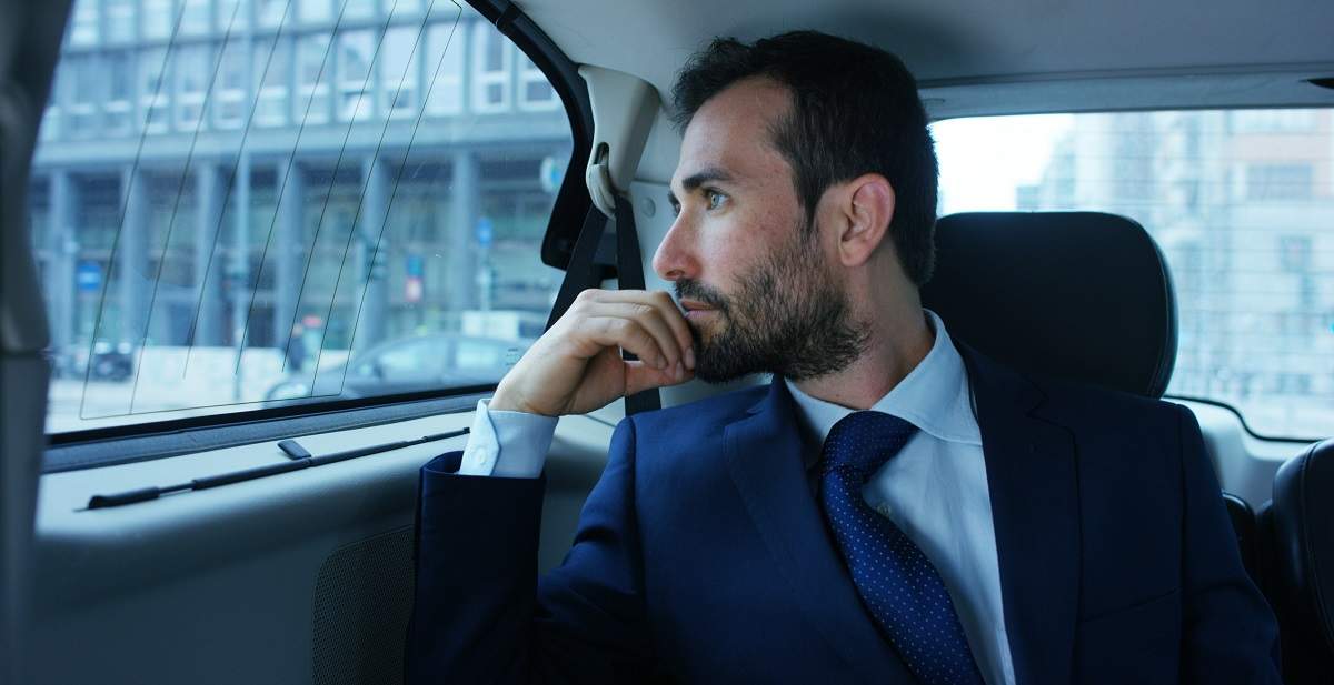 man staring out car window