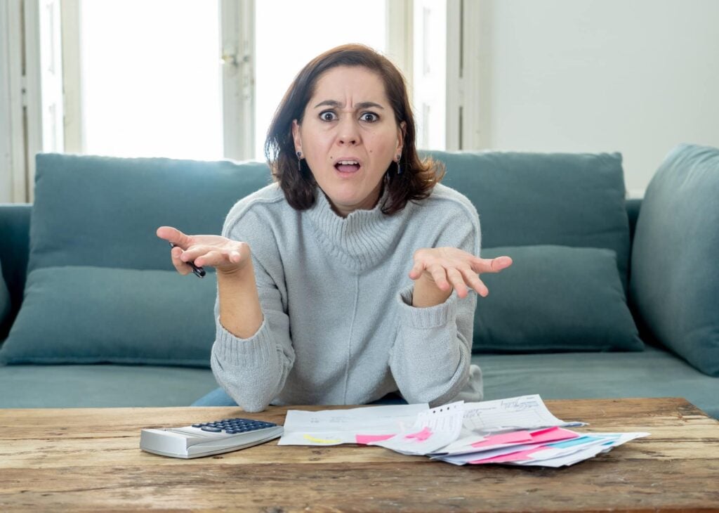 Upset young woman stressed about credit card debts and payments not happy accounting finances