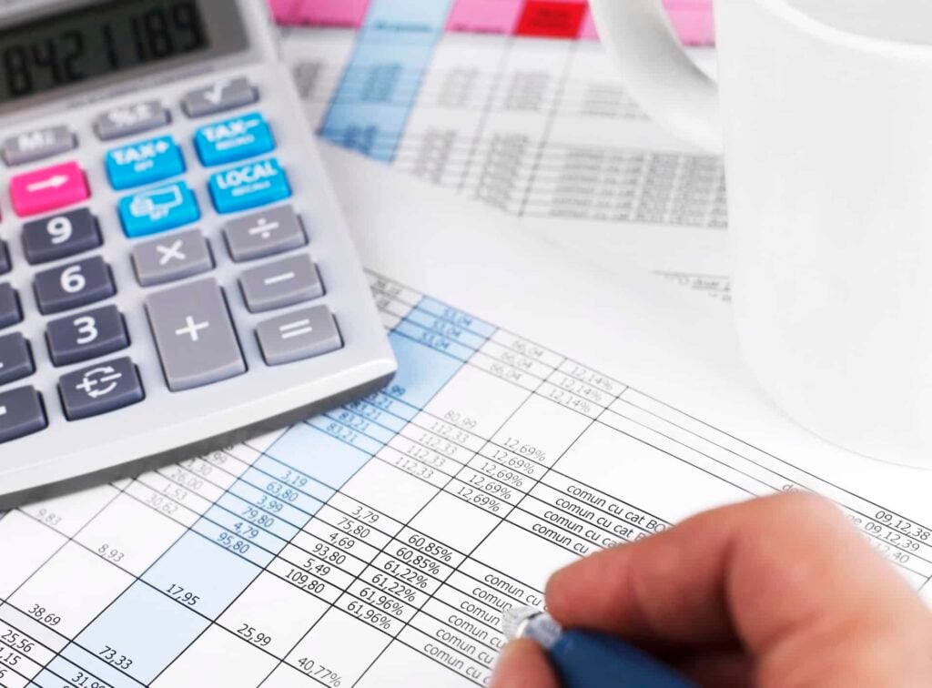 Financial report - Man with pen and calculator working on papers