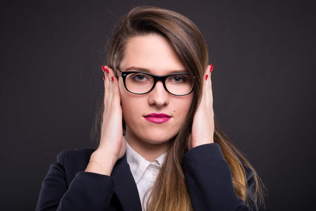 Businesswoman in the hear no evil pose