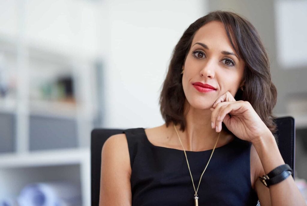 Portrait of an attractive businesswoman sitting in a chair in an office.