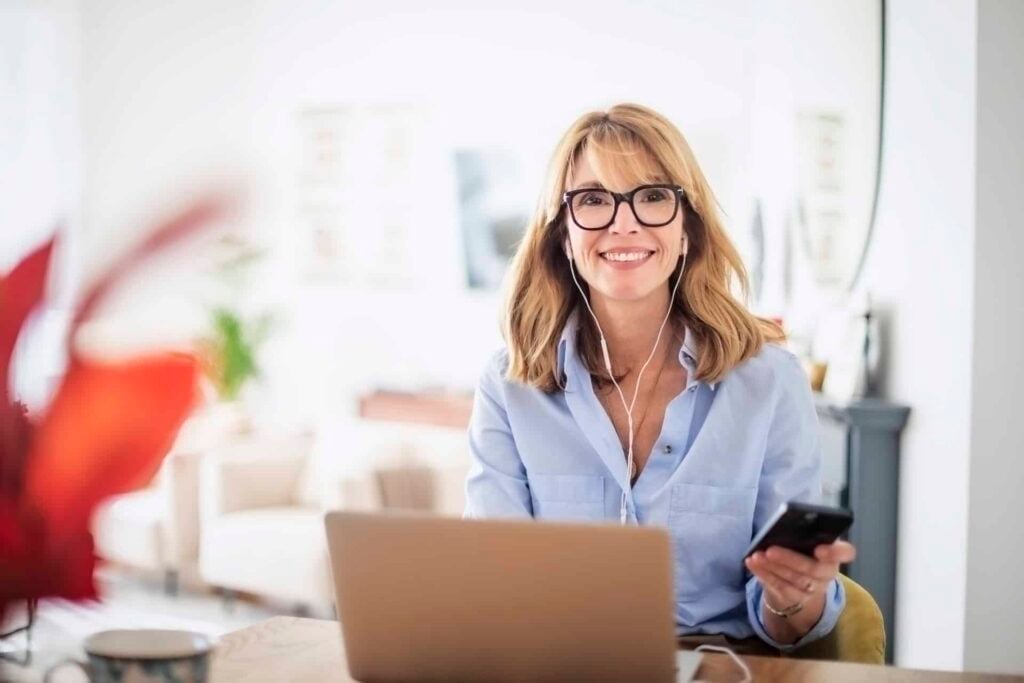 Attractive woman with earphone using her laptop at home